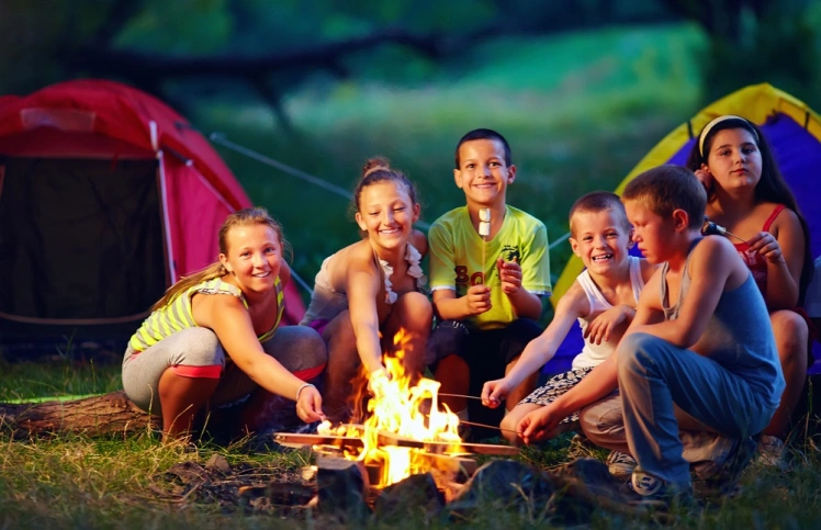 A-group-of-kids-sitting-around-the-campfire-on-a-Smoky-Mountain-camping-trip